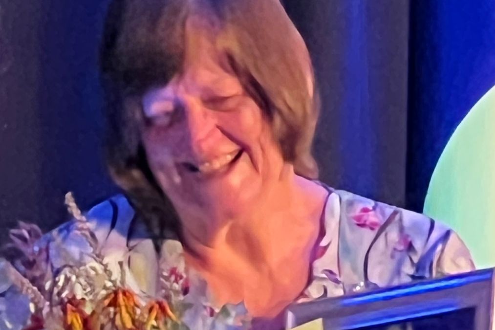 Sandy Smith presented with flowers, a medal and framed certificate as Redland's Citizen of the Year 2025.